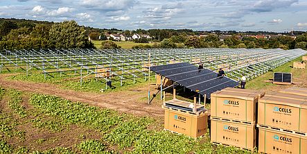 Erste Montagearbeiten am Solarpark Erste Montagearbeiten am Solarpark. Kisten mit Modulen stehen vor dem Gerüst der Photovoltaikanlage.