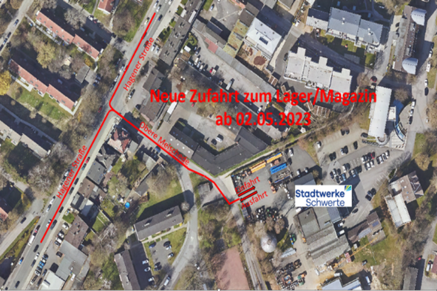 Vogelperspektive der Umgebung Stadtwerke Schwerte, erkennbar durch das Stadtwerke Schwerte Logo. Eine roter Informationstext ist sichtbar wo draufsteht: Neue Zufahrt zum Lager/Magazin ab 02.05.2023. Das Foto zeigt die Straßen "Hagener Straße" und "Obere Meisschale", die zur Einfahrt und Ausfahrt des Stadtwerke-Gebäudes führt